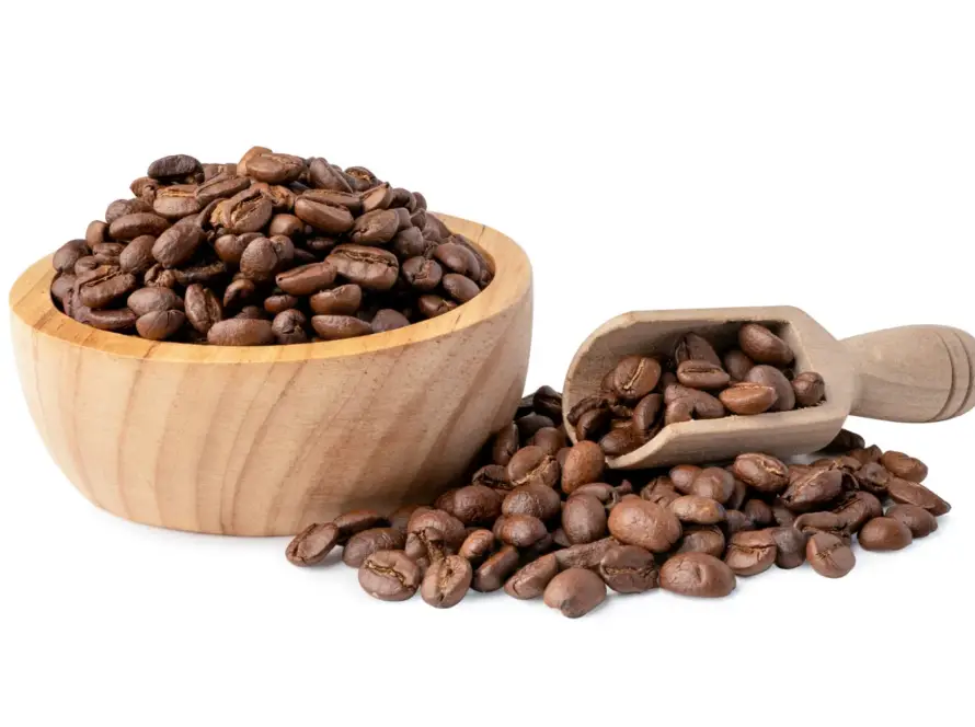 Café en grano natural en taza de madera con granos sueltos